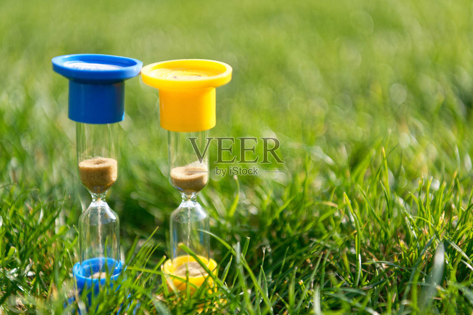 绿草地上的沙漏照片摄影图片