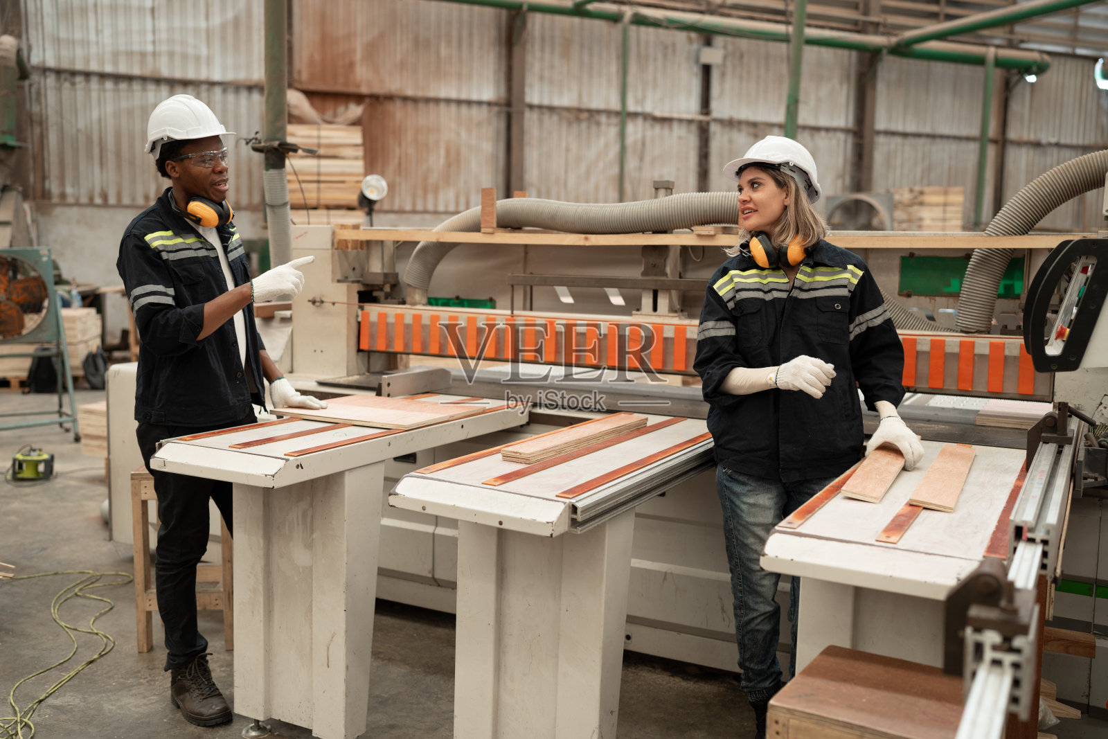 手工工人非裔美国男人和白人女人在木材厂用机器和木材工作照片摄影图片