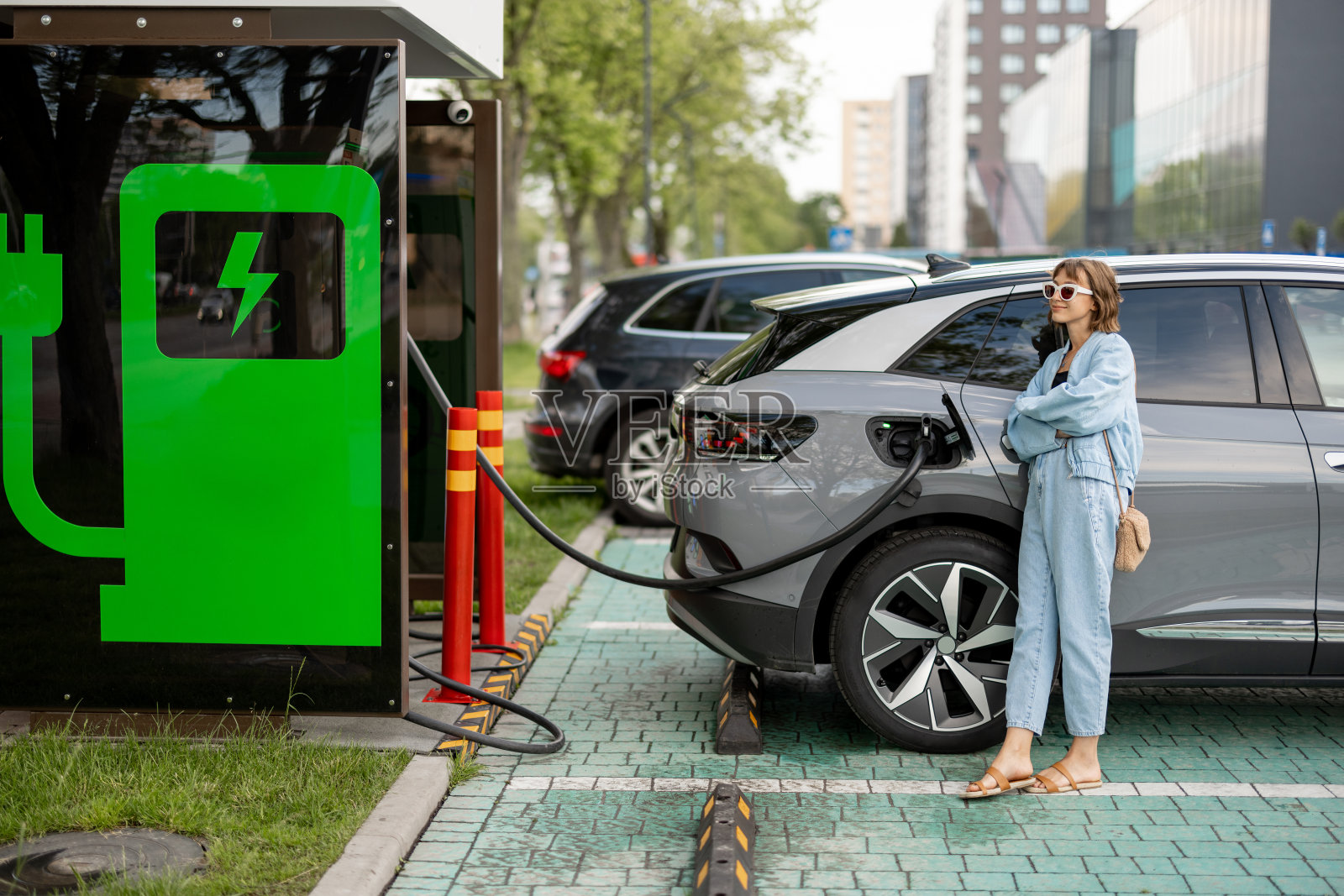 等待电动车充电的妇女照片摄影图片