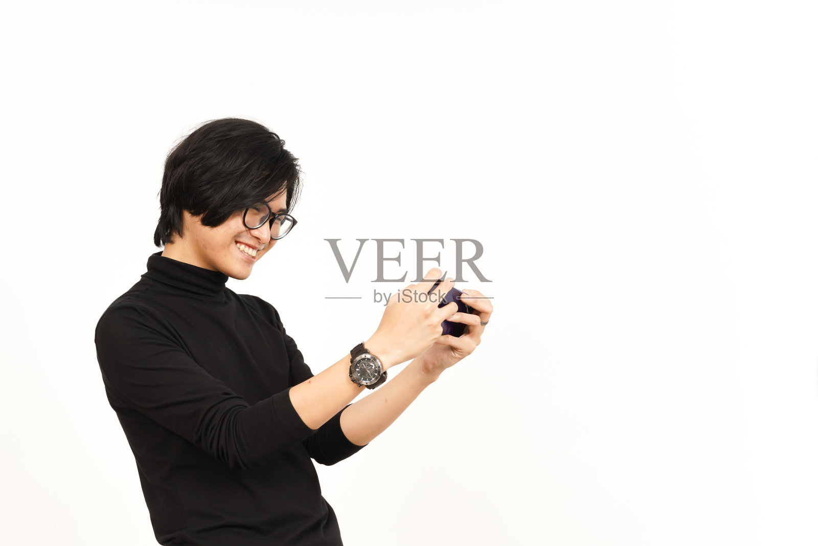 在白色背景下玩亚洲帅哥的手机游戏照片摄影图片