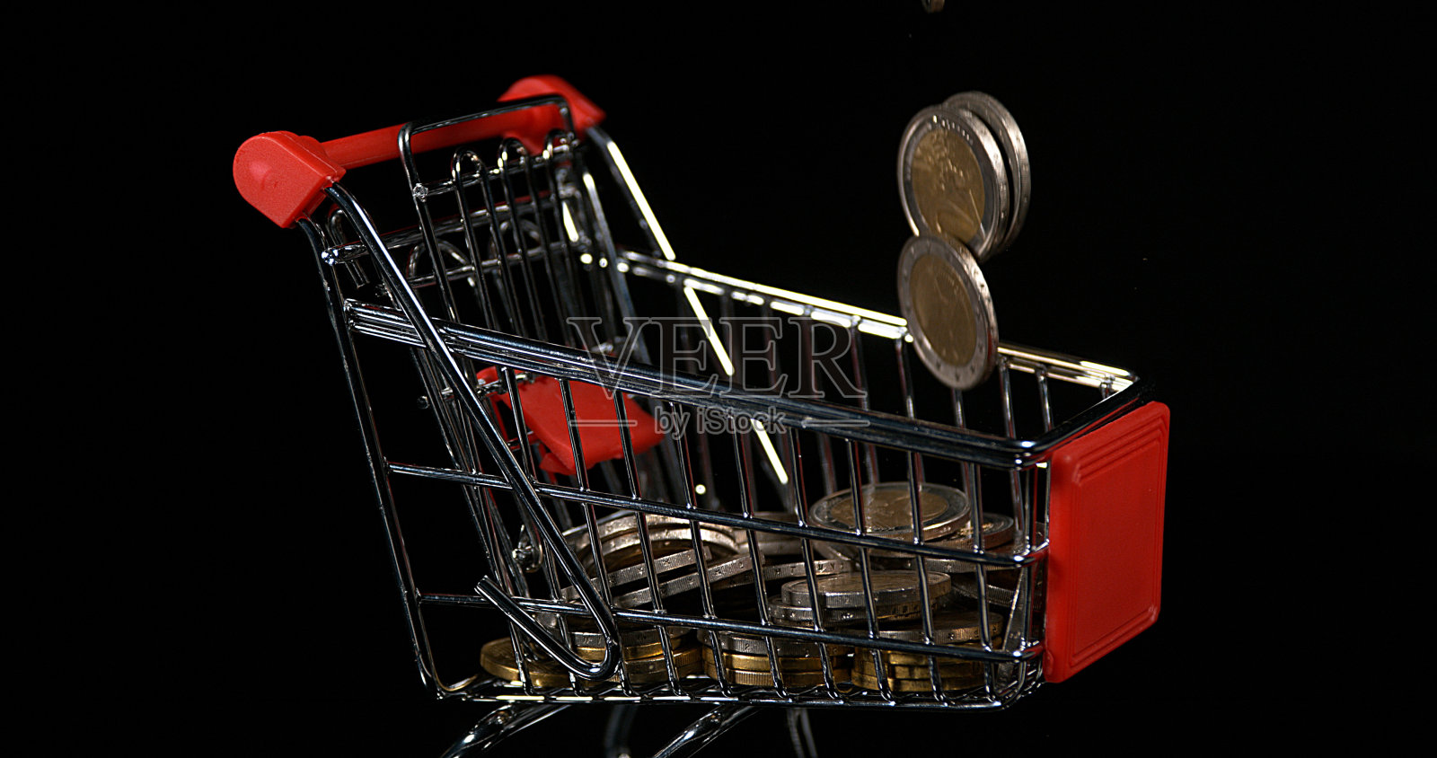 欧元硬币在手推车滚动对黑色背景照片摄影图片