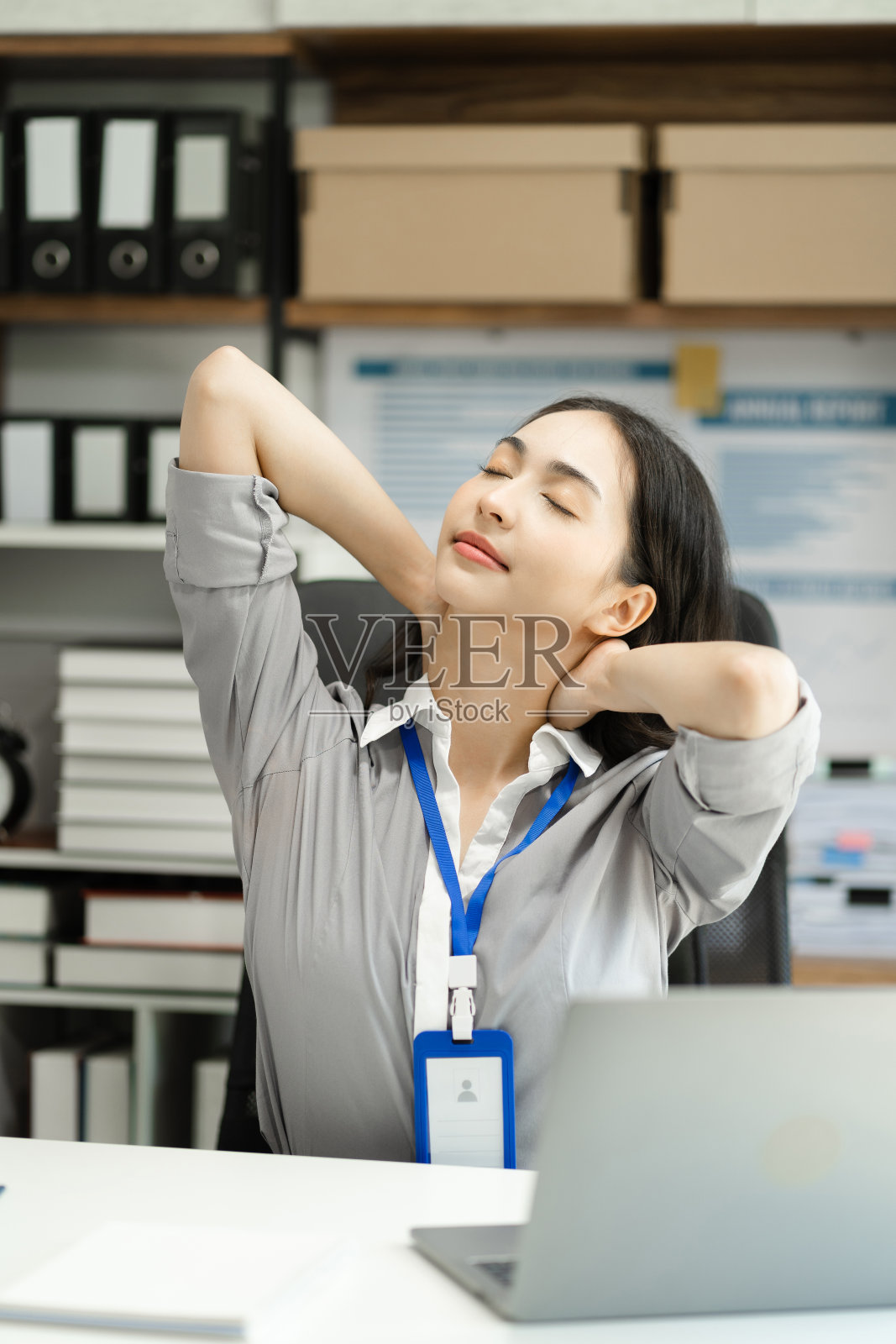 女商人之所以做拉伸姿势是因为在办公室坐得太久，办公室综合症的概念。照片摄影图片