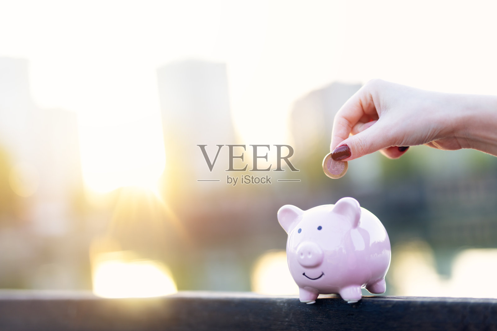 手把硬币放进存钱罐里照片摄影图片