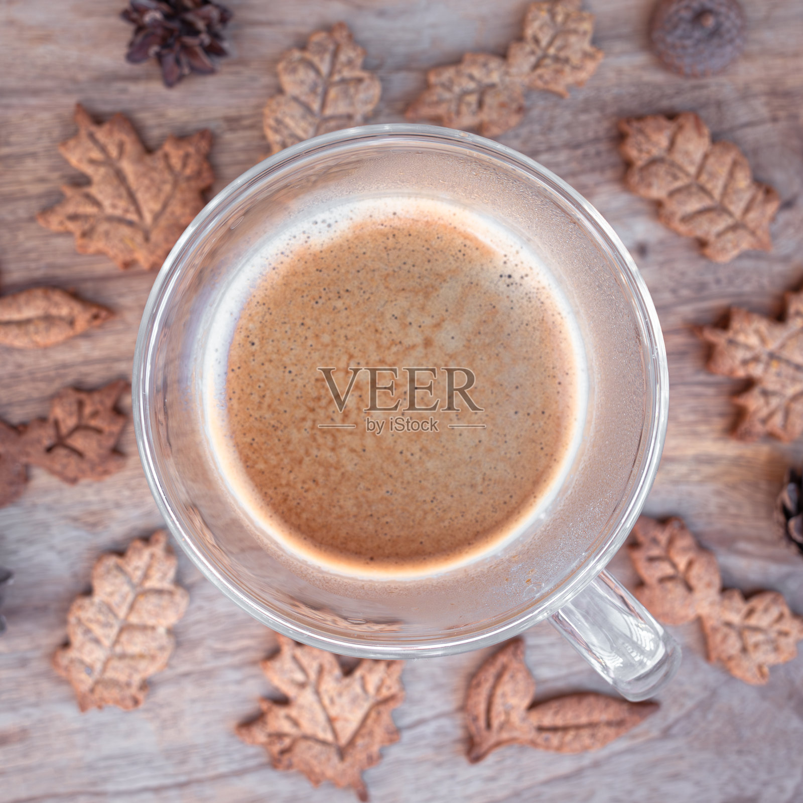 一杯咖啡和在木板上做成秋叶形状的饼干照片摄影图片