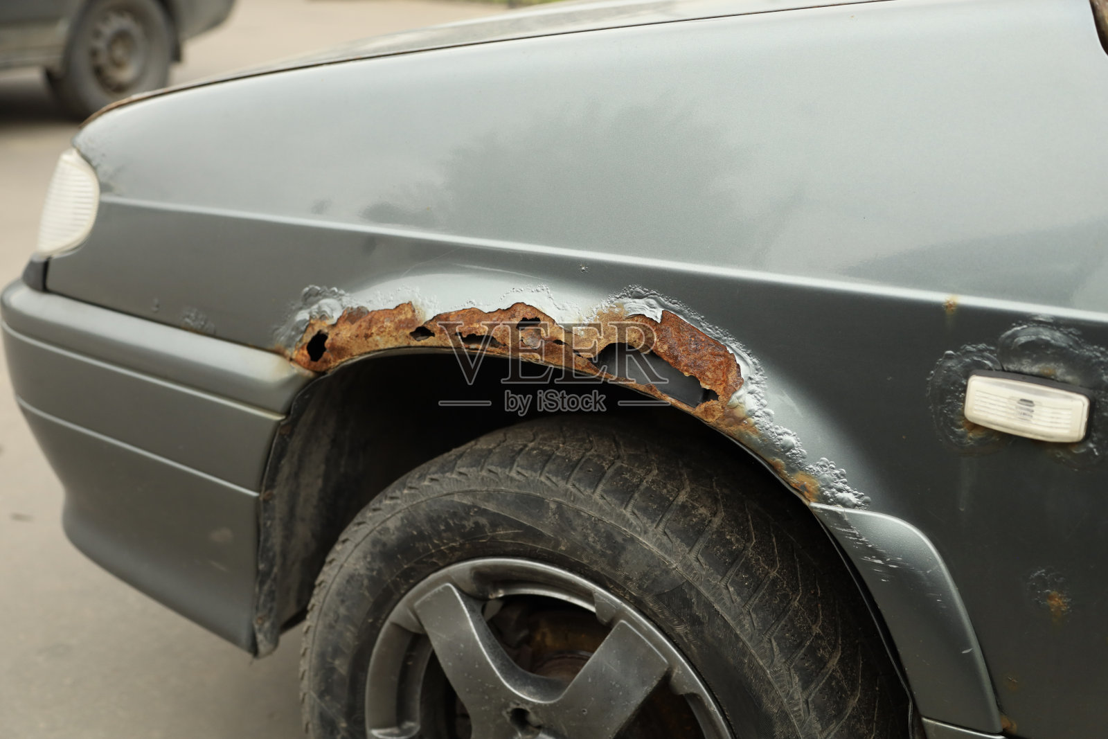 漏水生锈的汽车前挡泥板。生锈的车身，生锈的特写。照片摄影图片