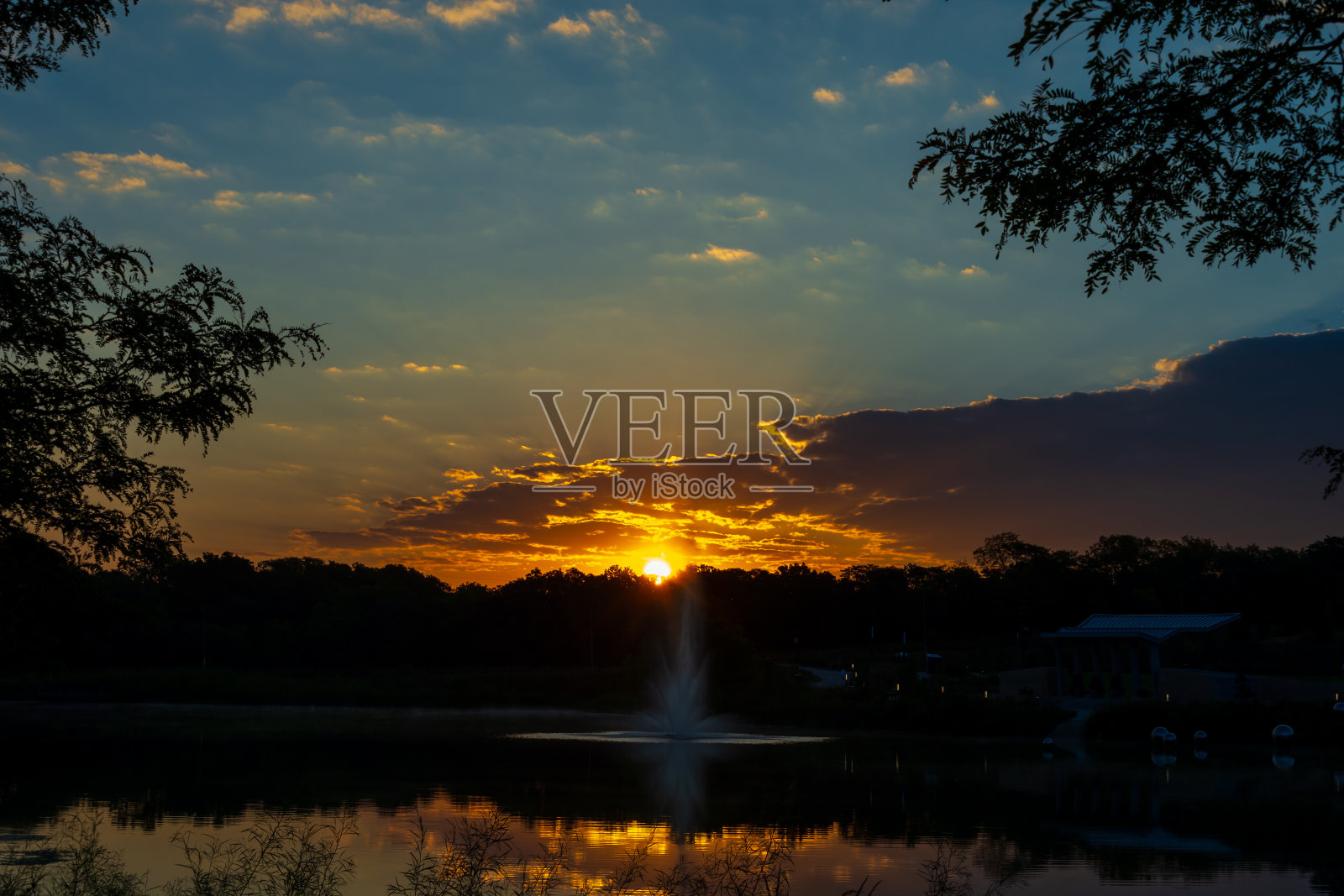 日出的光线反射在云层和池塘上。照片摄影图片