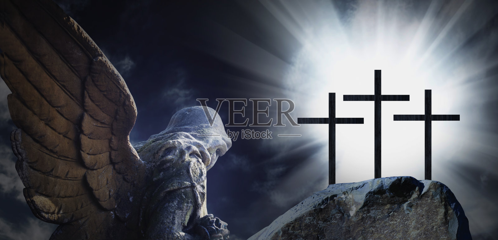 天使和三个十字架的剪影在岩石山上对戏剧性的天空背景，象征基督受难。照片摄影图片