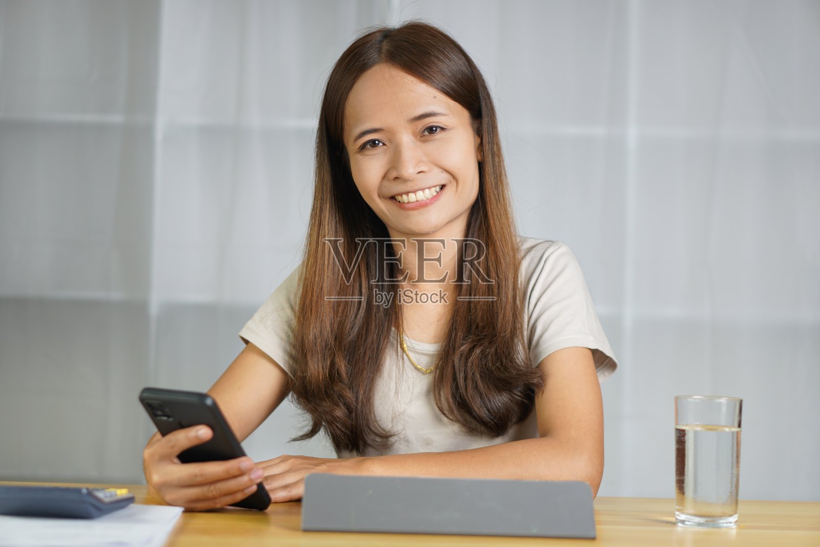 在家工作的亚洲妇女通过电话与客户联系照片摄影图片