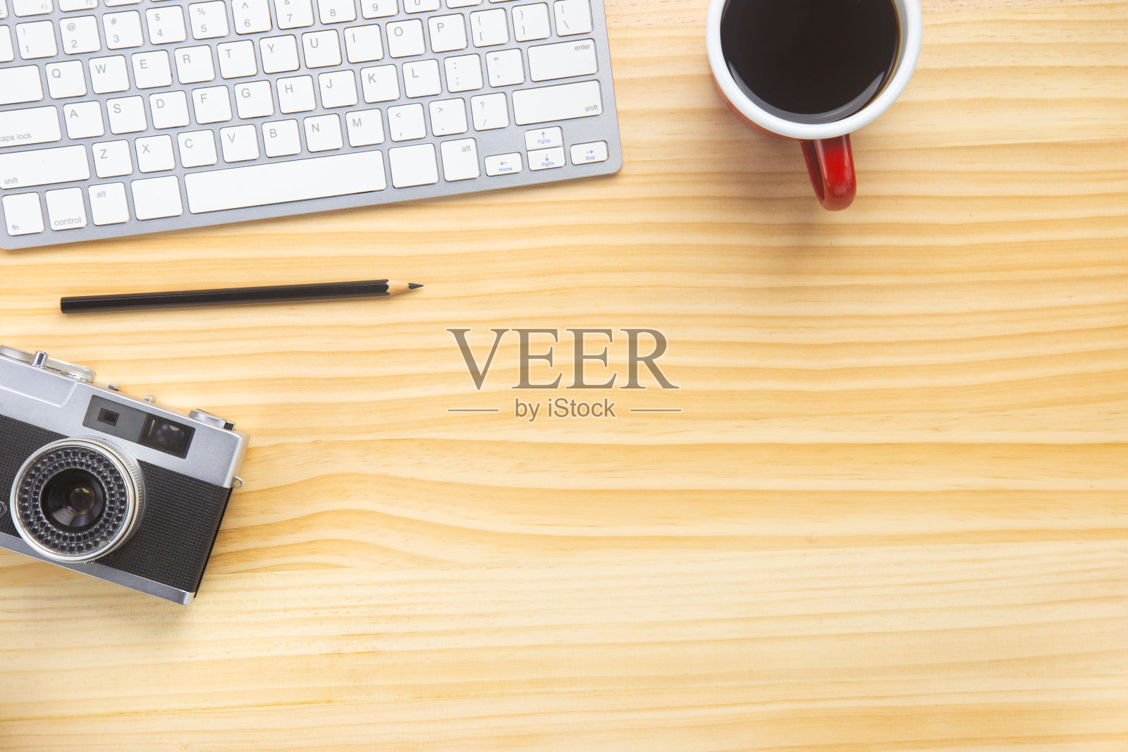 木质办公桌办公室配有笔记本电脑、智能手机等工作用品和一杯咖啡。带有用于输入文本的复制空间的顶视图。设计师工作空间的桌子上的基本元素在平面上。照片摄影图片