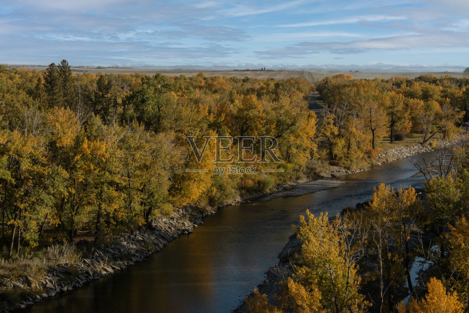 从高处俯瞰河流，河岸两边都是秋色的树木照片摄影图片
