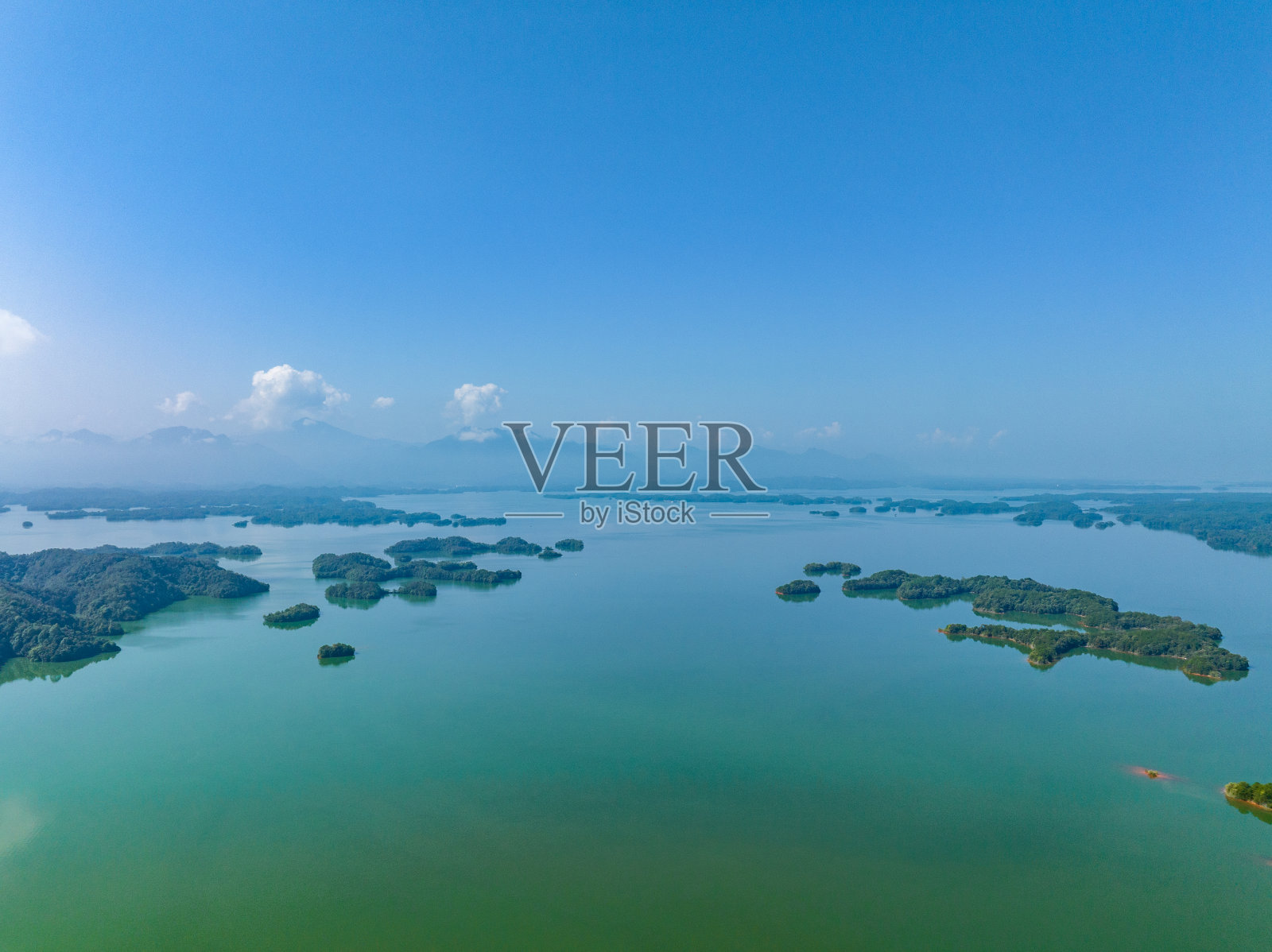 清澈的湖水和绿色的山地自然景观。照片摄影图片