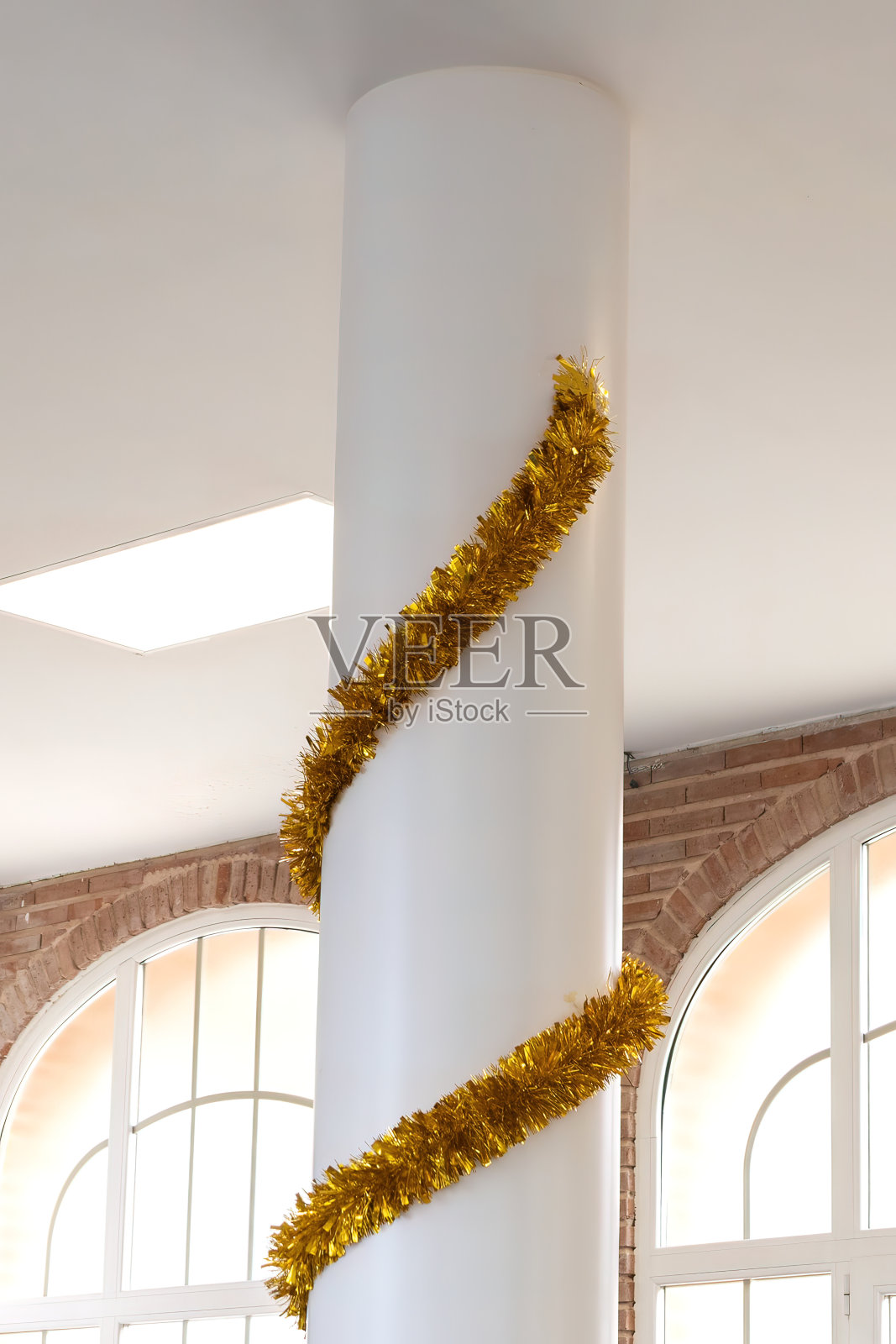 黄色的圣诞装饰丝带像金箔一样围绕着柱子给人欢乐照片摄影图片