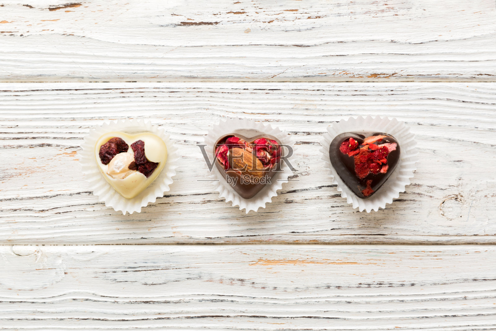 巧克力糖果，心形形状，水果和坚果在彩色背景上。顶视图与空间的文字，假期的概念照片摄影图片