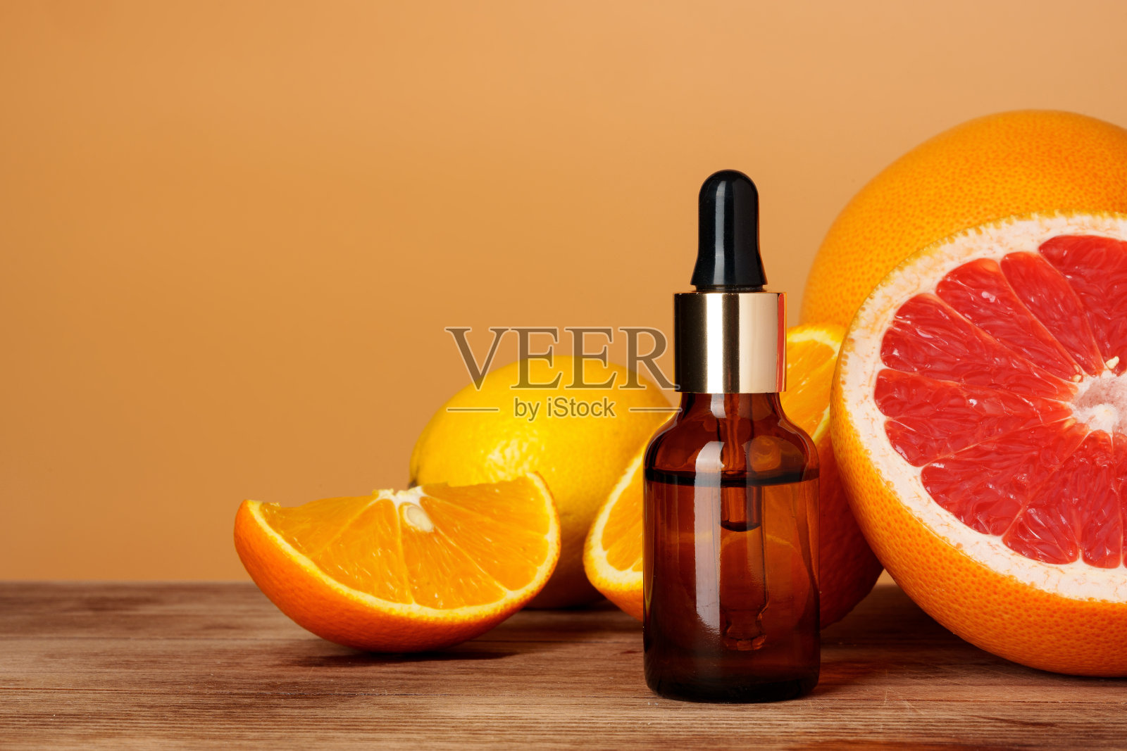 玻璃瓶与柑橘精油在橙色的背景照片摄影图片