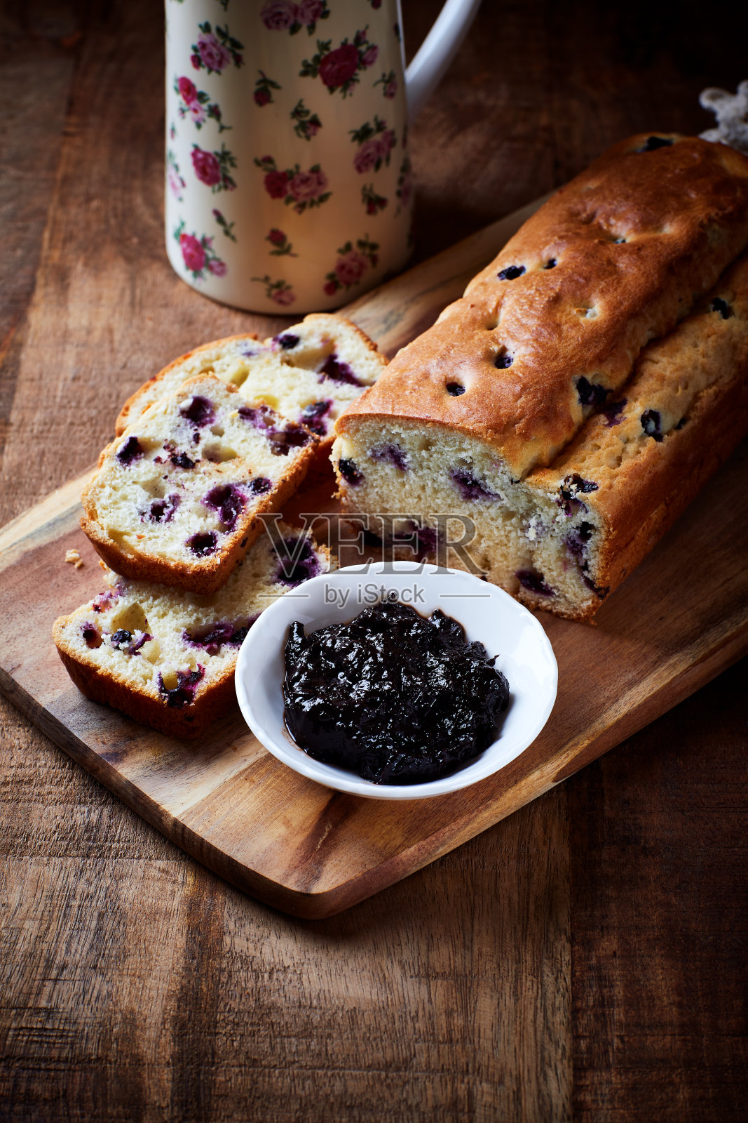 果酱和自家烤的越橘蛋糕。都是乡村风格的。深色木制背景。副本的空间。照片摄影图片