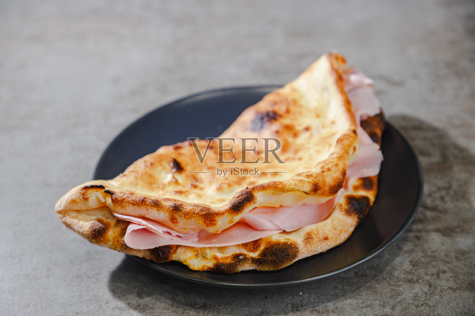 盘里的折叠面饼三明治配上美味的火腿片照片摄影图片