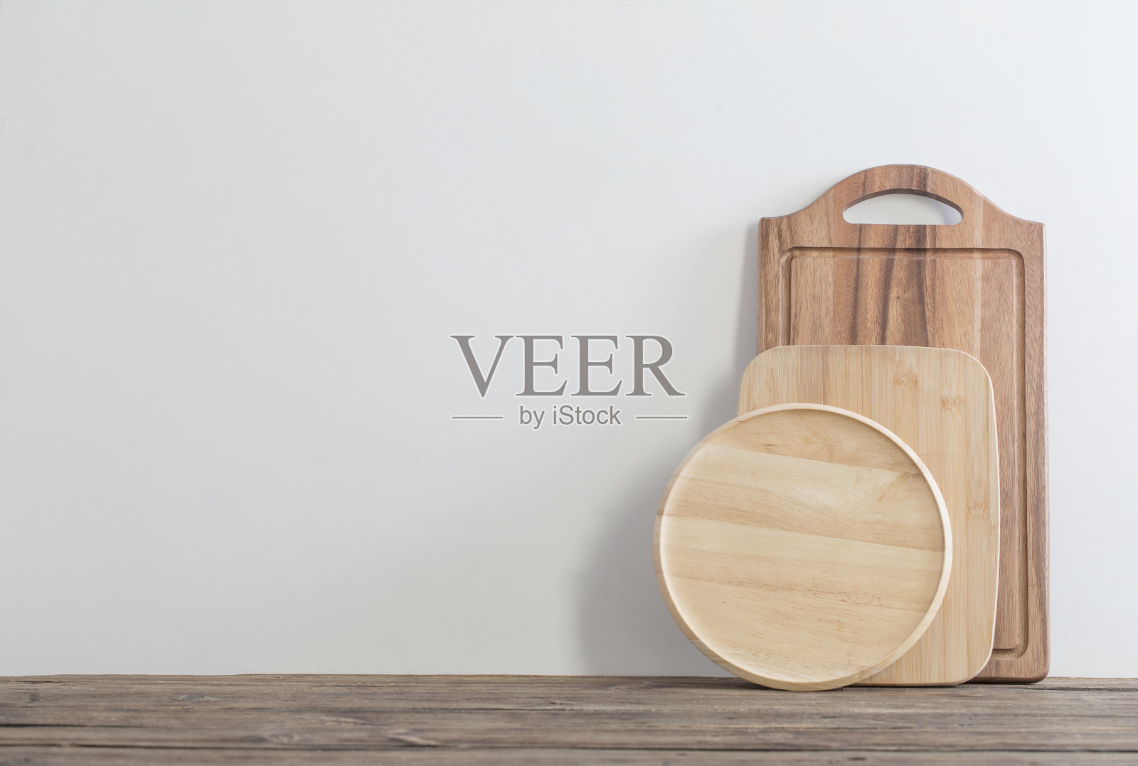 砧板放在木桌上，背景是白墙照片摄影图片