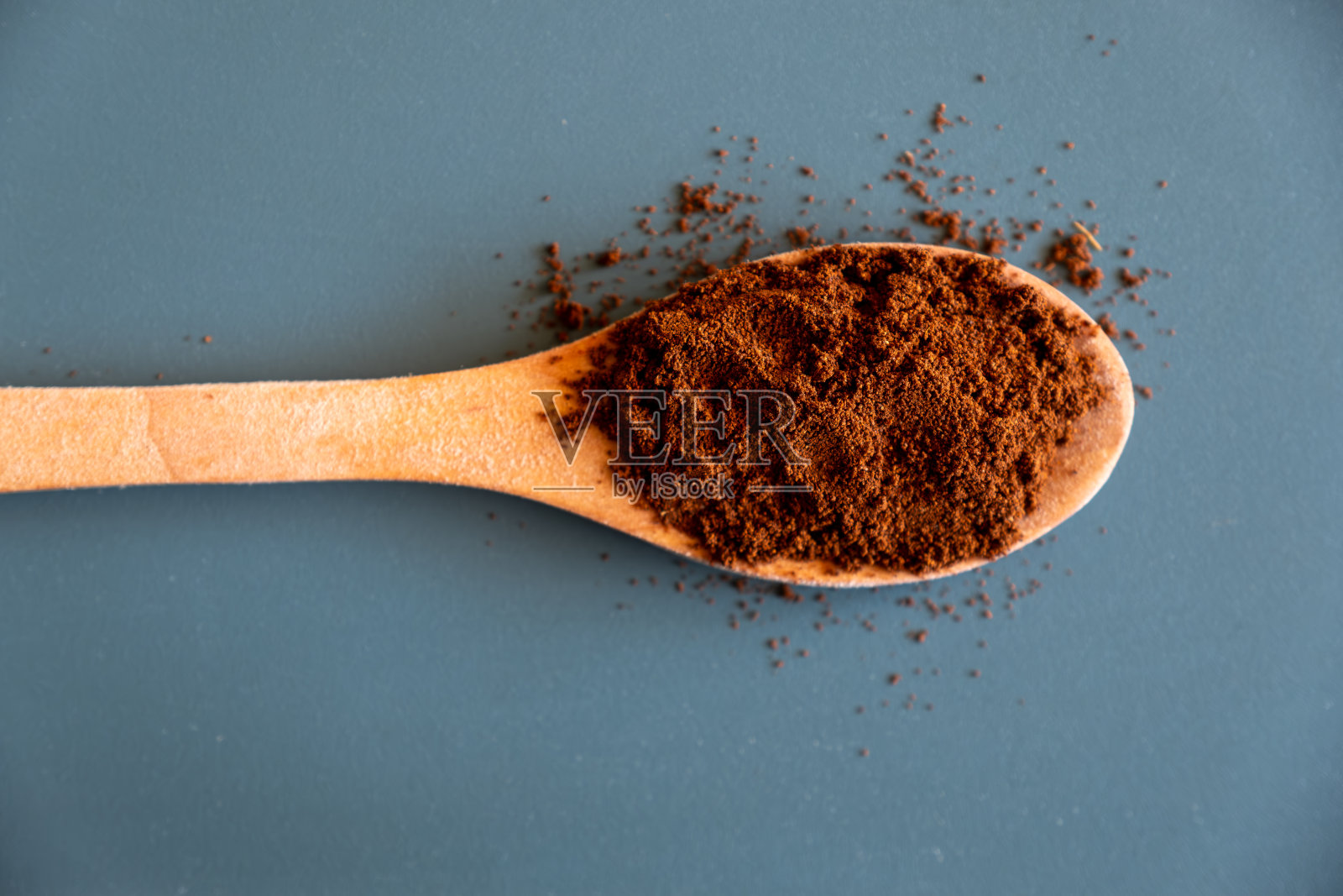 绿色背景上的一勺咖啡粉照片摄影图片