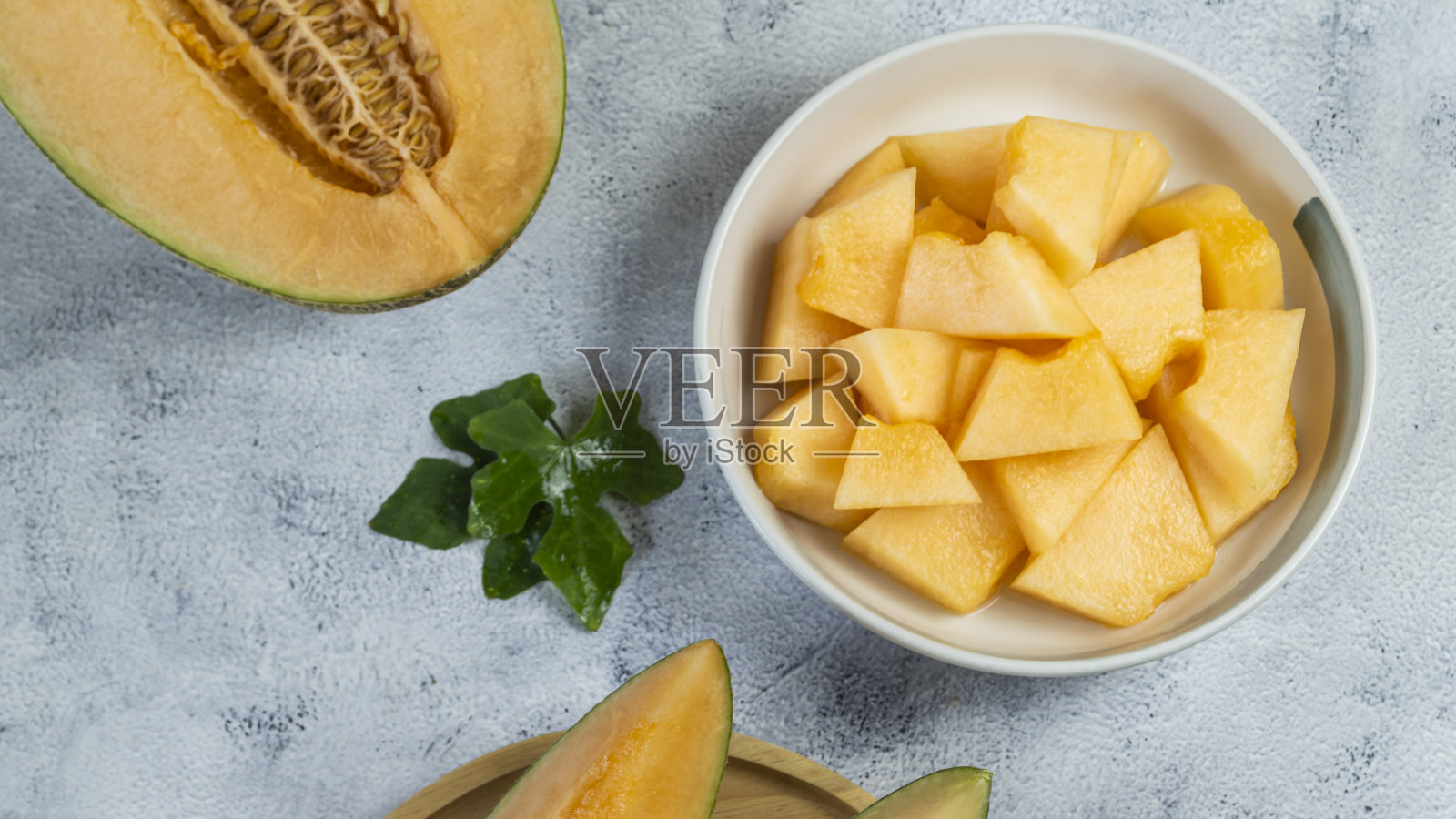 将成熟的黄色哈密瓜切成块，放入碗中照片摄影图片