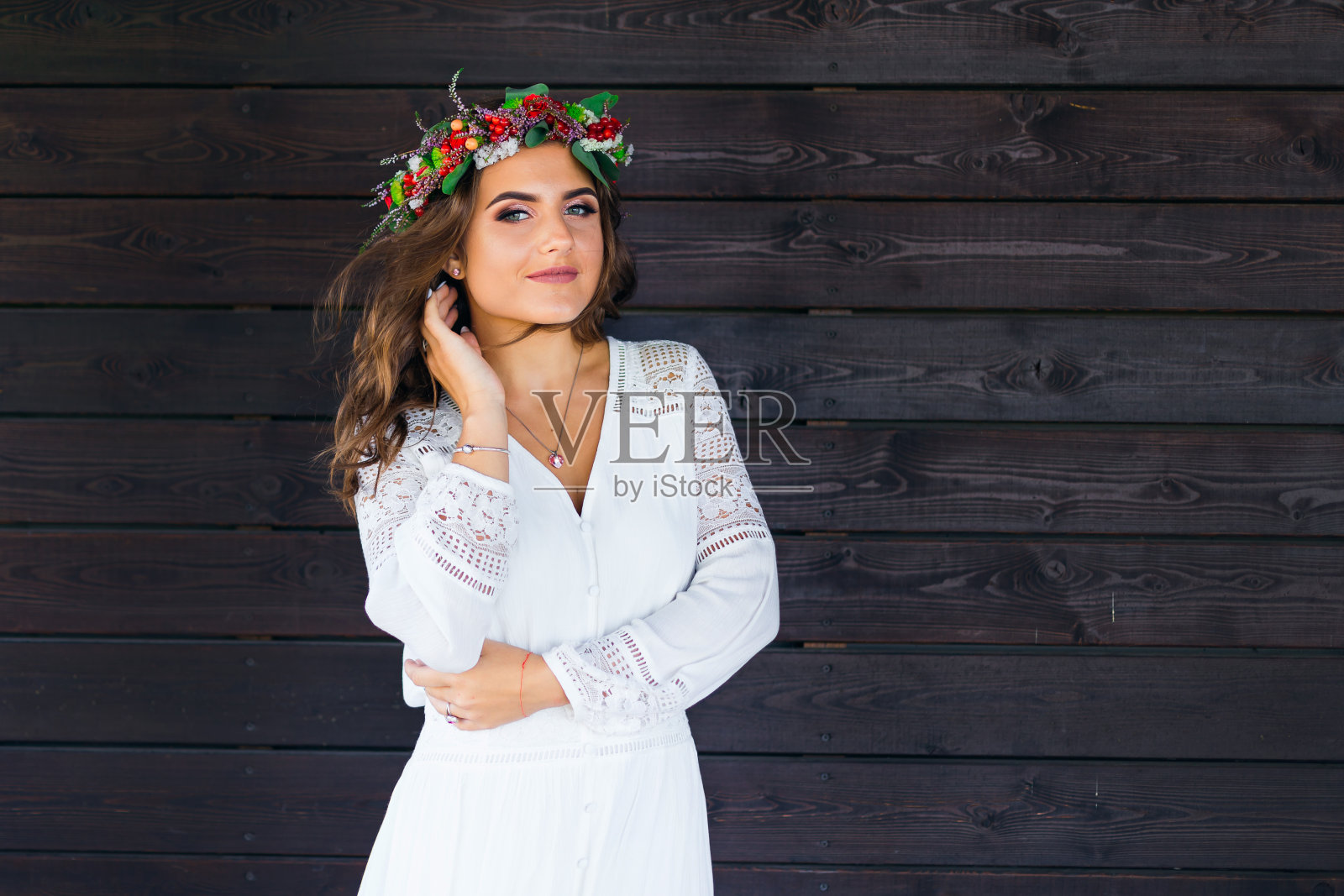 一个戴着花圈的年轻女子看着镜头照片摄影图片