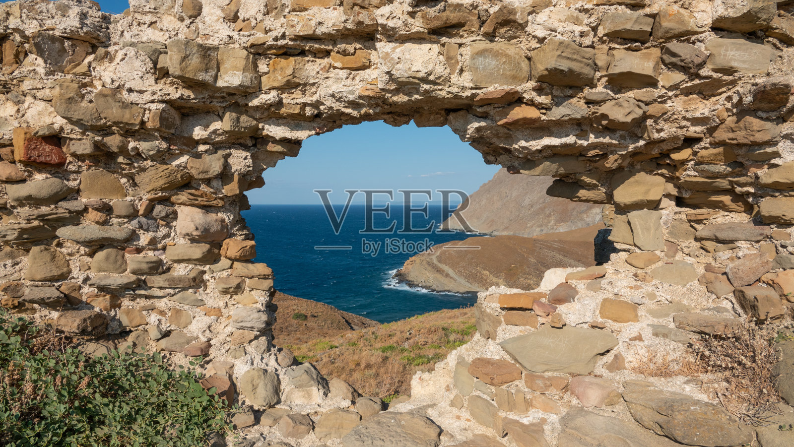 卡列科伊的海景被古老的卡列科伊城堡的窗户框住——土耳其爱琴海岛屿格克切达照片摄影图片