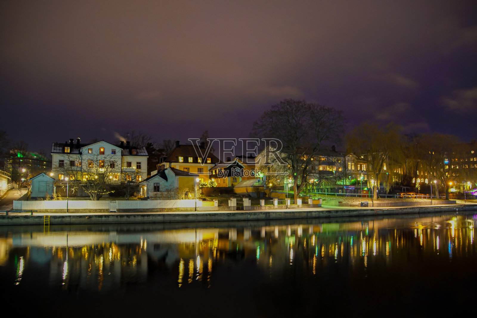 夜晚，照亮的建筑物映衬着天空，俯瞰湖泊的美景照片摄影图片