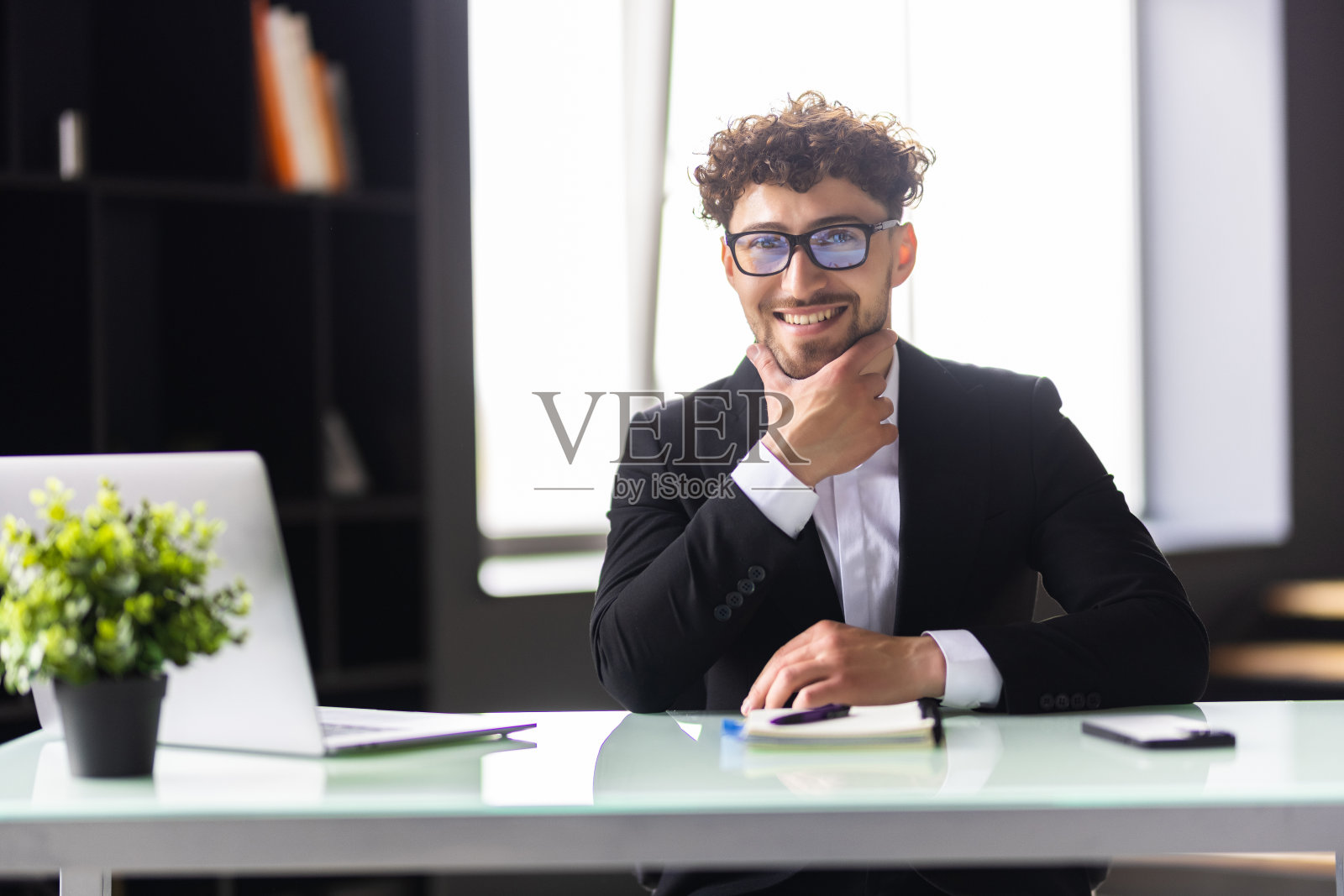 坐在办公桌前用笔记本电脑工作的商人照片摄影图片