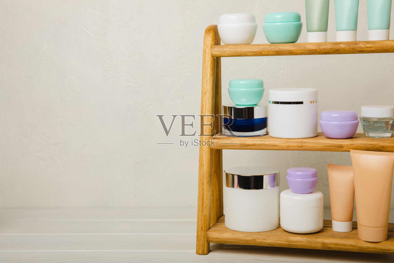 皮肤护理阶段:在白色木制背景上为健康皮肤提供精华液和洗液，磨砂，去皮和清洁。美容和化妆品的概念。木架子上的一套化妆品。照片摄影图片