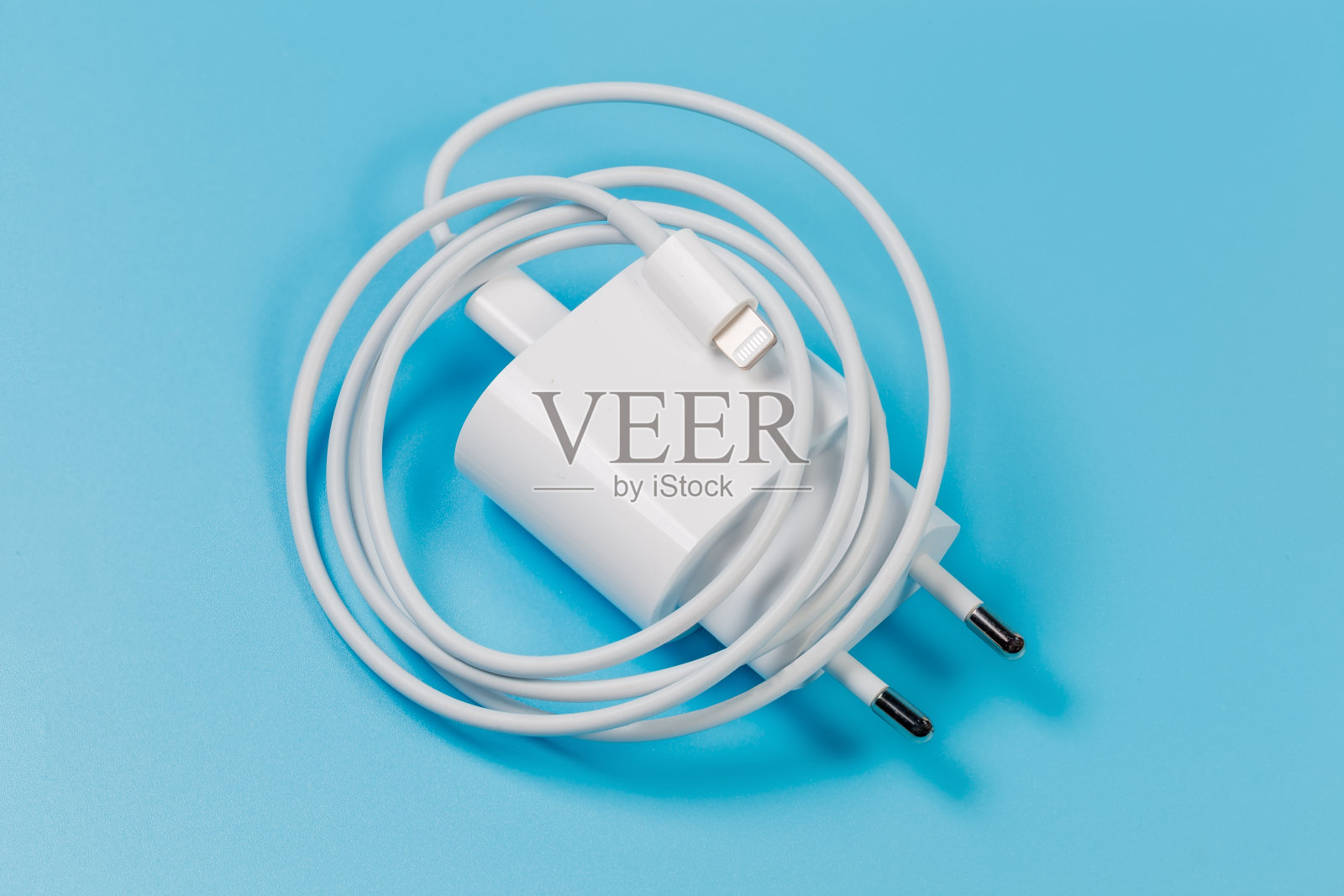 电子设备充电器与交流欧洲插头和连接的闪电电缆照片摄影图片