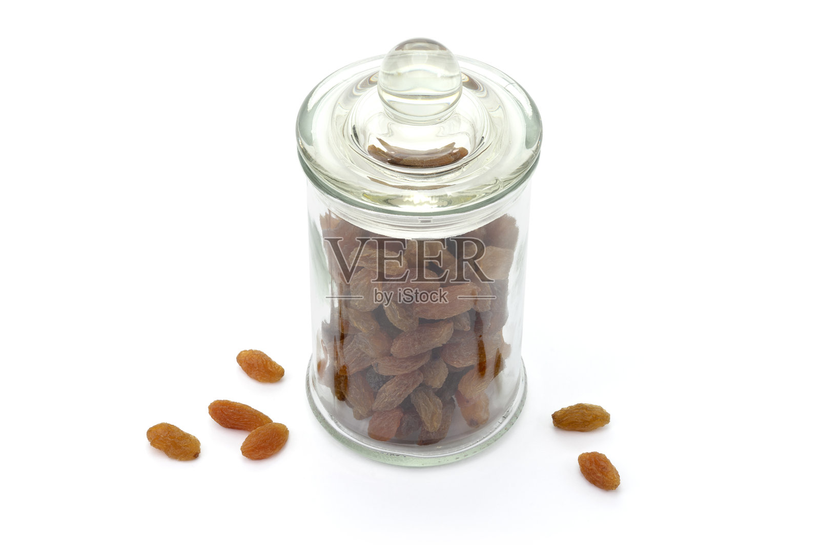 白色背景上孤立的玻璃罐里的葡萄干。干无核葡萄。健康营养的水果。作为健康零食的干果。照片摄影图片