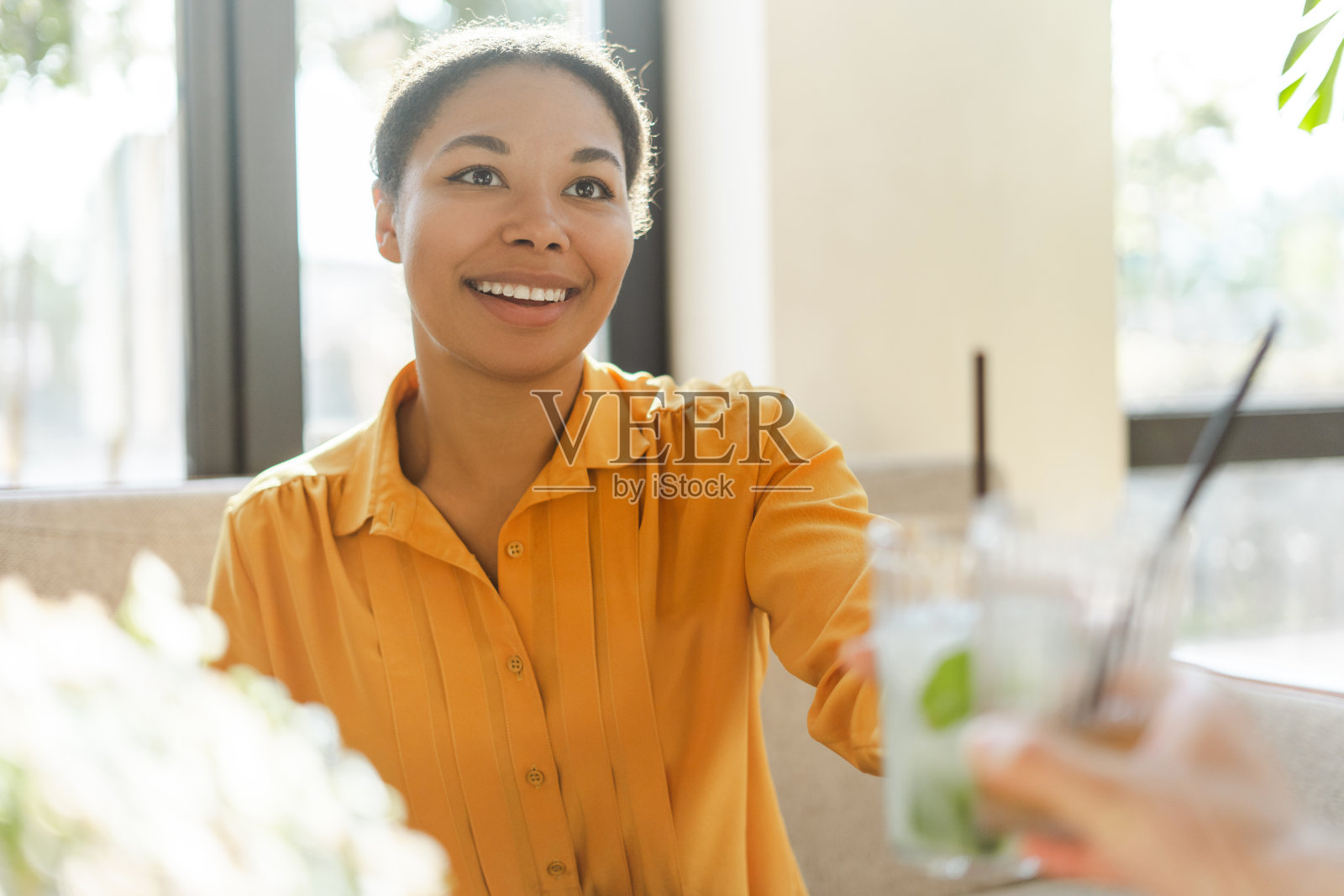 一个面带微笑的美丽的非裔美国妇女的肖像，她正在烘烤新鲜可口的柠檬水照片摄影图片