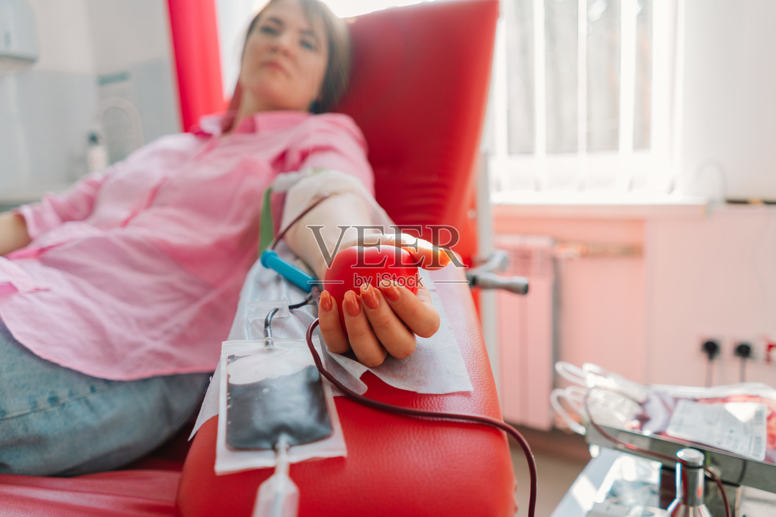 年轻女子在医院献血。照片摄影图片