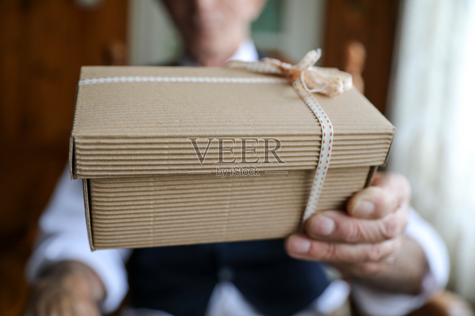 老人手里拿着礼品盒照片摄影图片