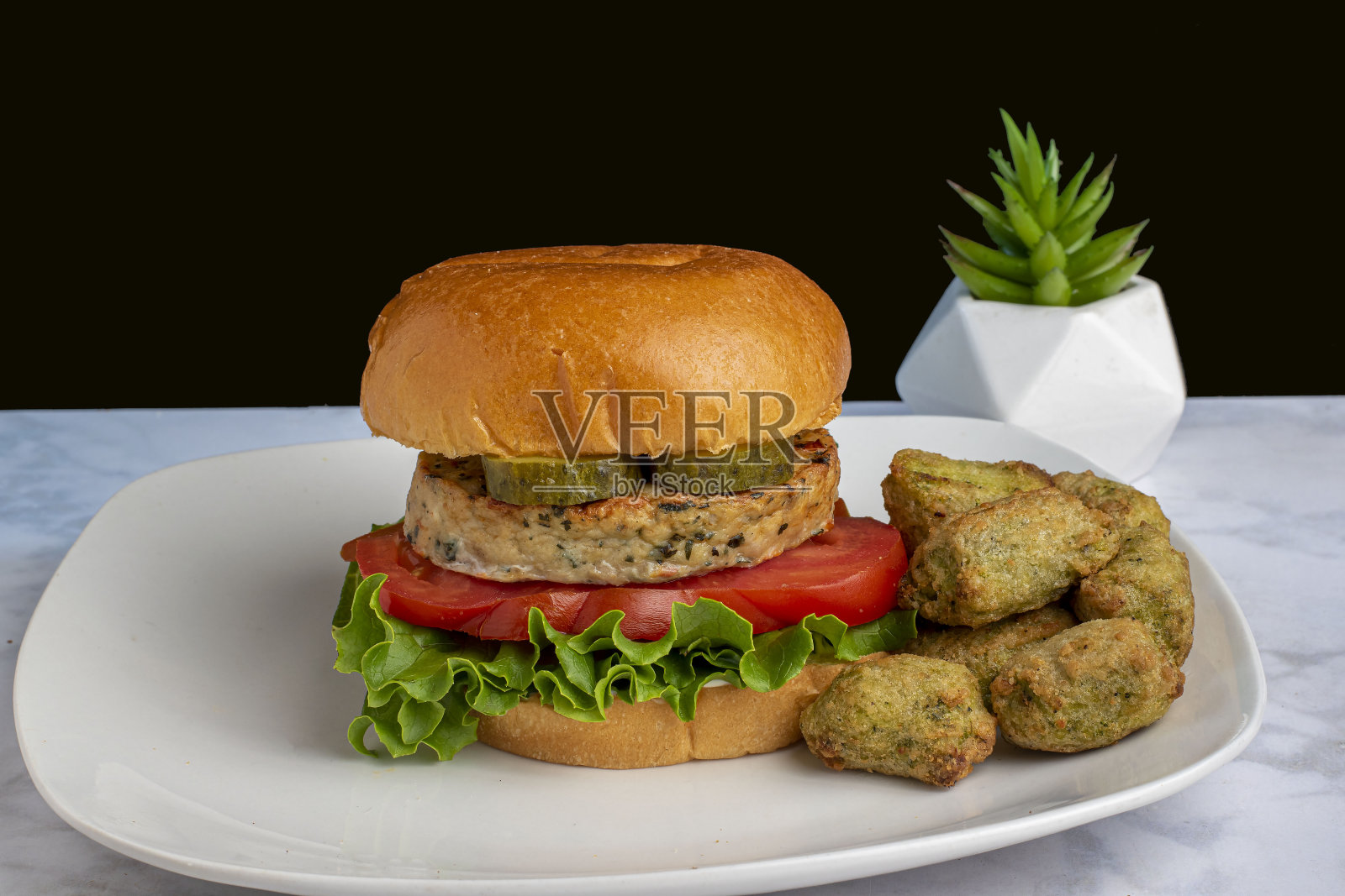 以植物为基础的汉堡顶部有泡菜和蔬菜土豆泥照片摄影图片