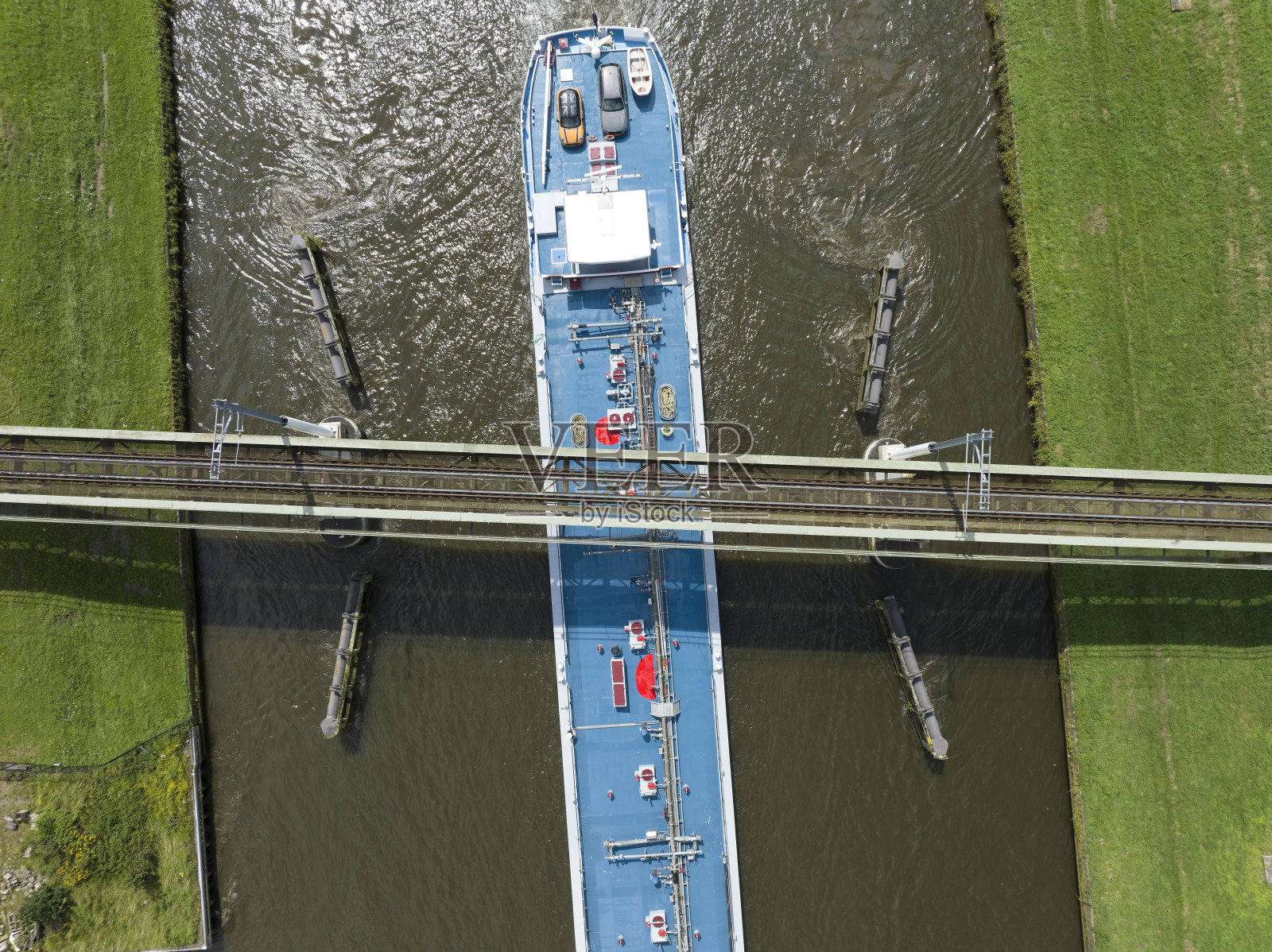 火车行驶在铁路桥上，轮船驶过运河照片摄影图片