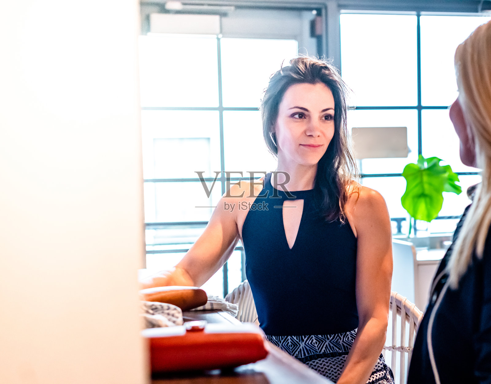 两个美丽的千禧一代女性坐在酒吧或餐厅聊天照片摄影图片