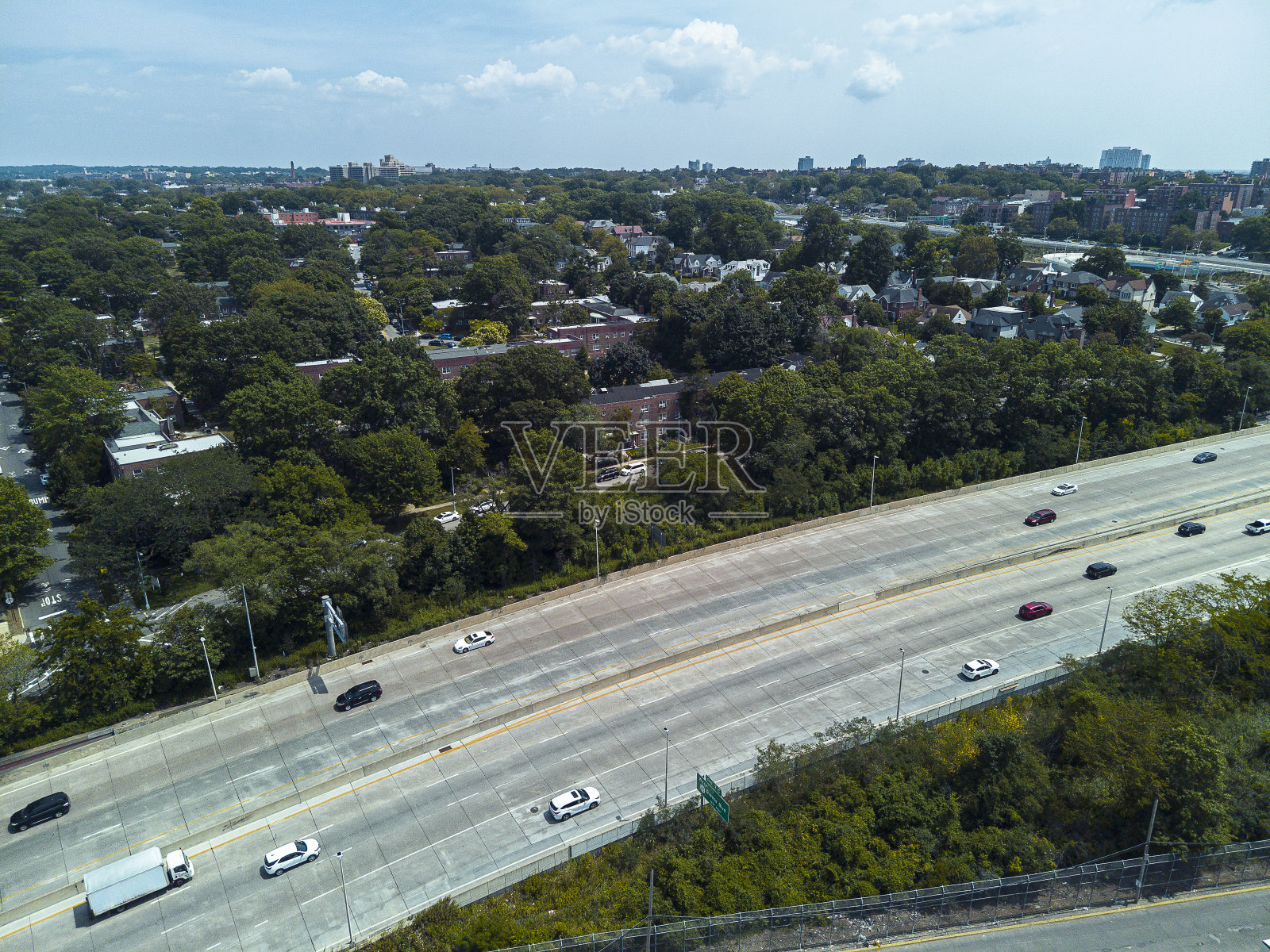 大中央公园大道上的汽车沿着住宅区在皇后区，纽约。蓝天映衬下的城市风光。空中拍摄照片摄影图片