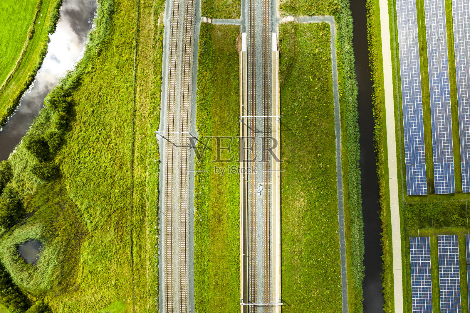 从上面看，太阳能电池板旁边的铁轨照片摄影图片