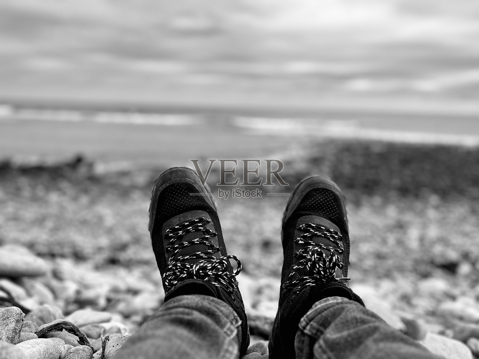 一个疲惫的徒步旅行者坐在诺森伯兰郡的岩石上照片摄影图片