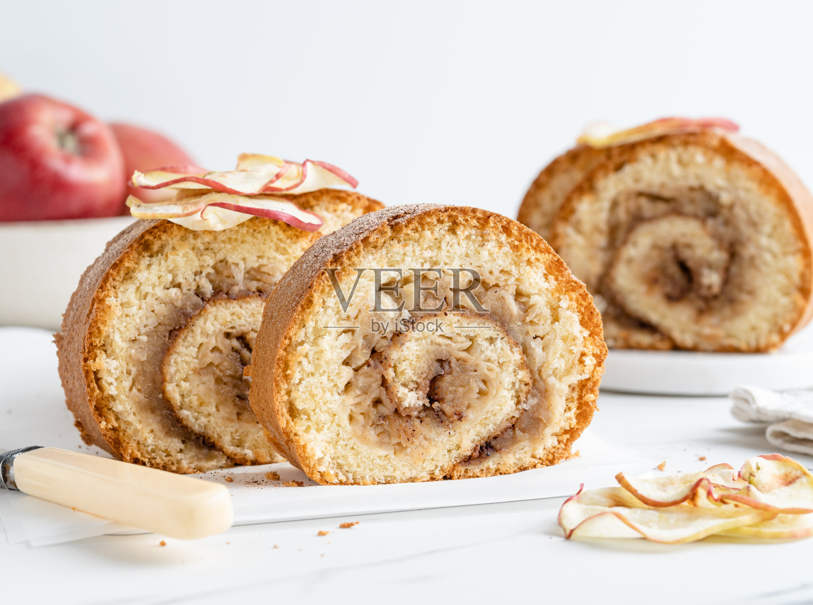 苹果蛋糕。甜苹果卷，酥皮面团和烤苹果馅。特写镜头。白色大理石背景。照片摄影图片