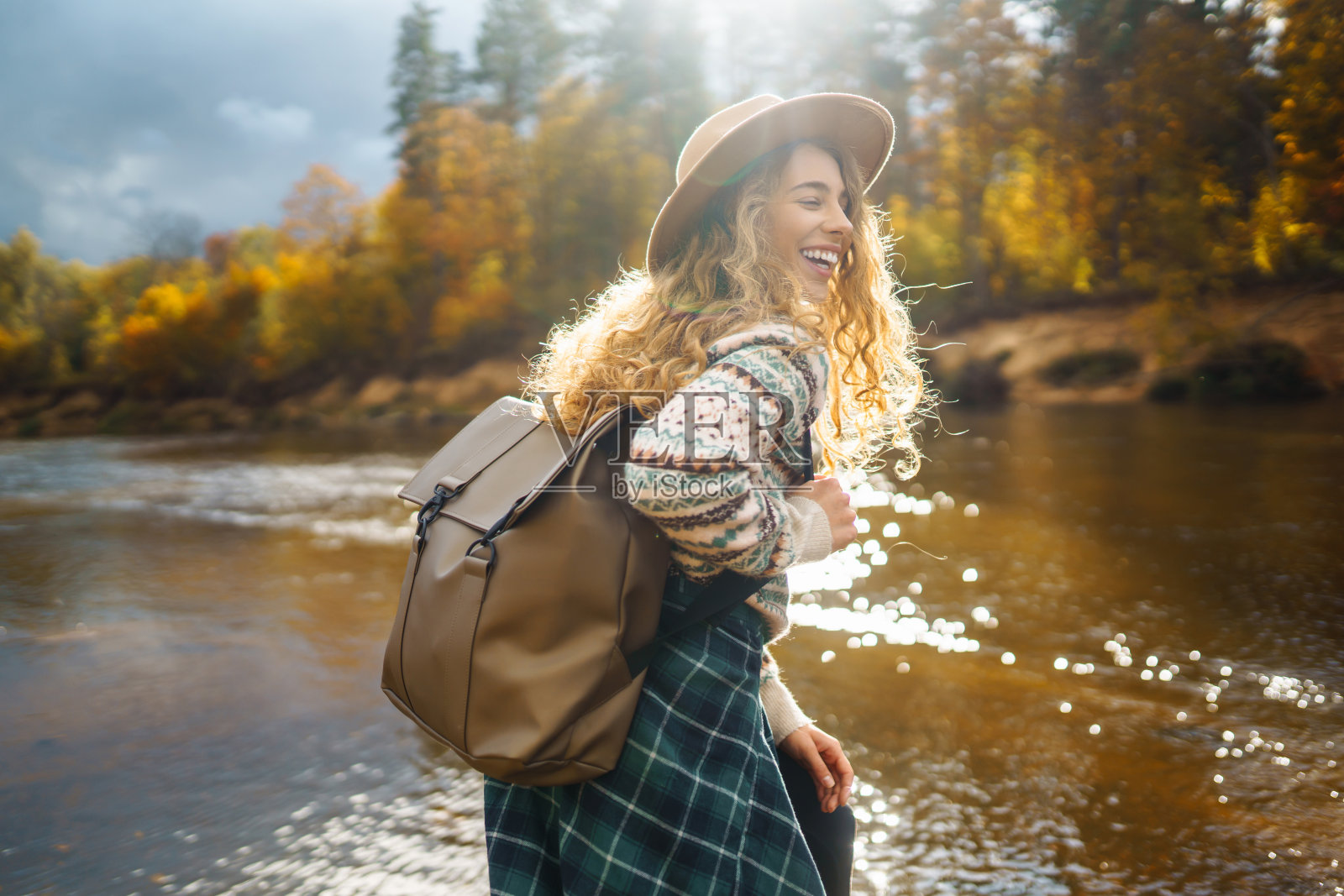秋天的游客在大自然中，沿着河边散步。照片摄影图片
