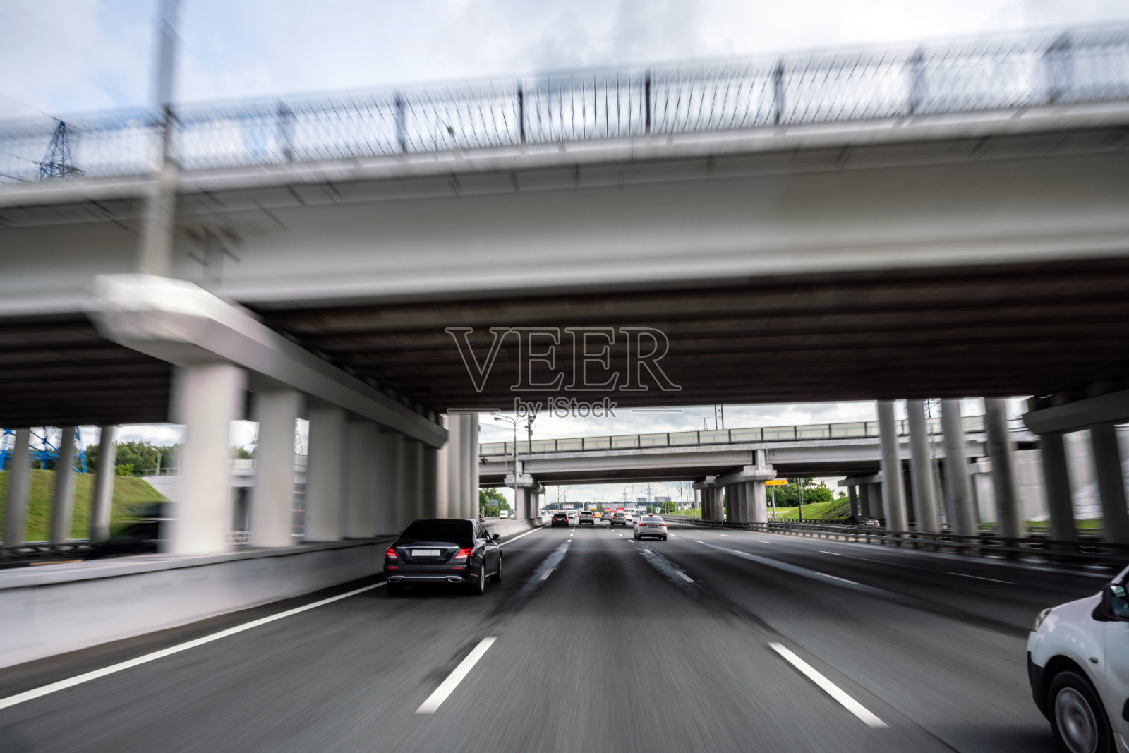 行驶在多车道高速公路上，接近公路上的汽车桥照片摄影图片