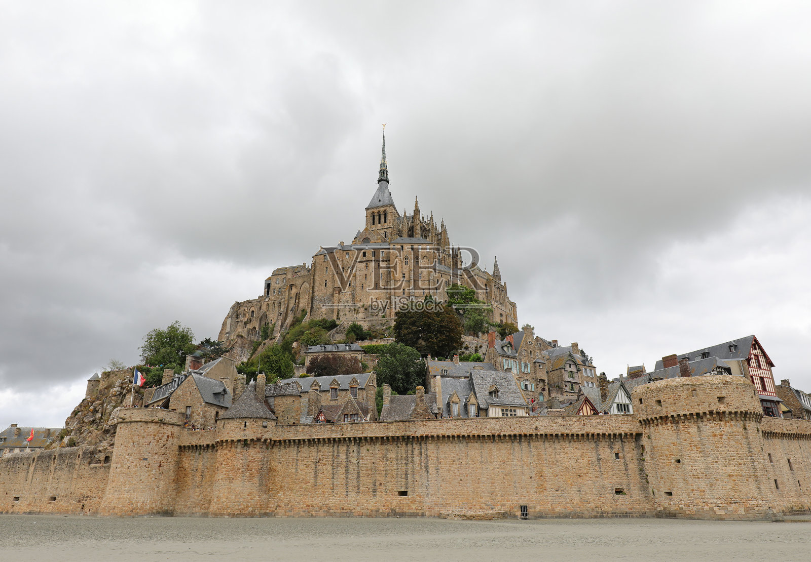 法国退潮时的圣米歇尔山修道院和防御墙照片摄影图片