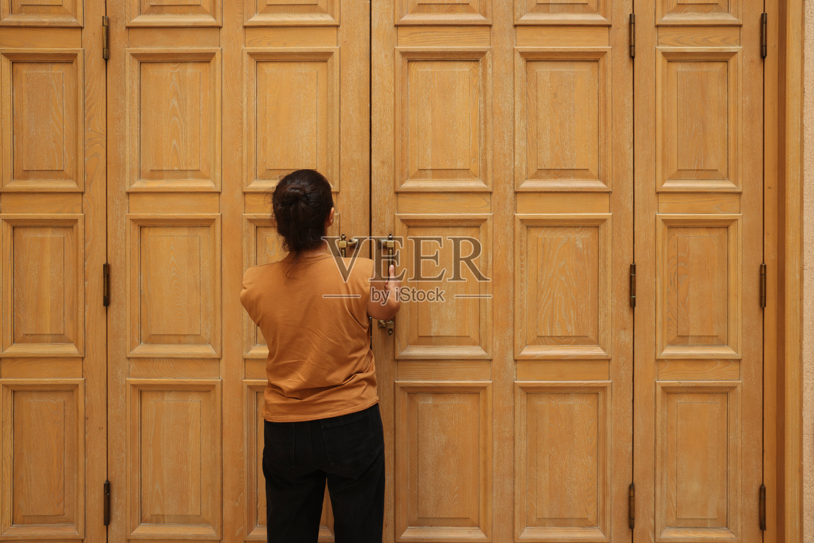 一个女人站在木门前照片摄影图片