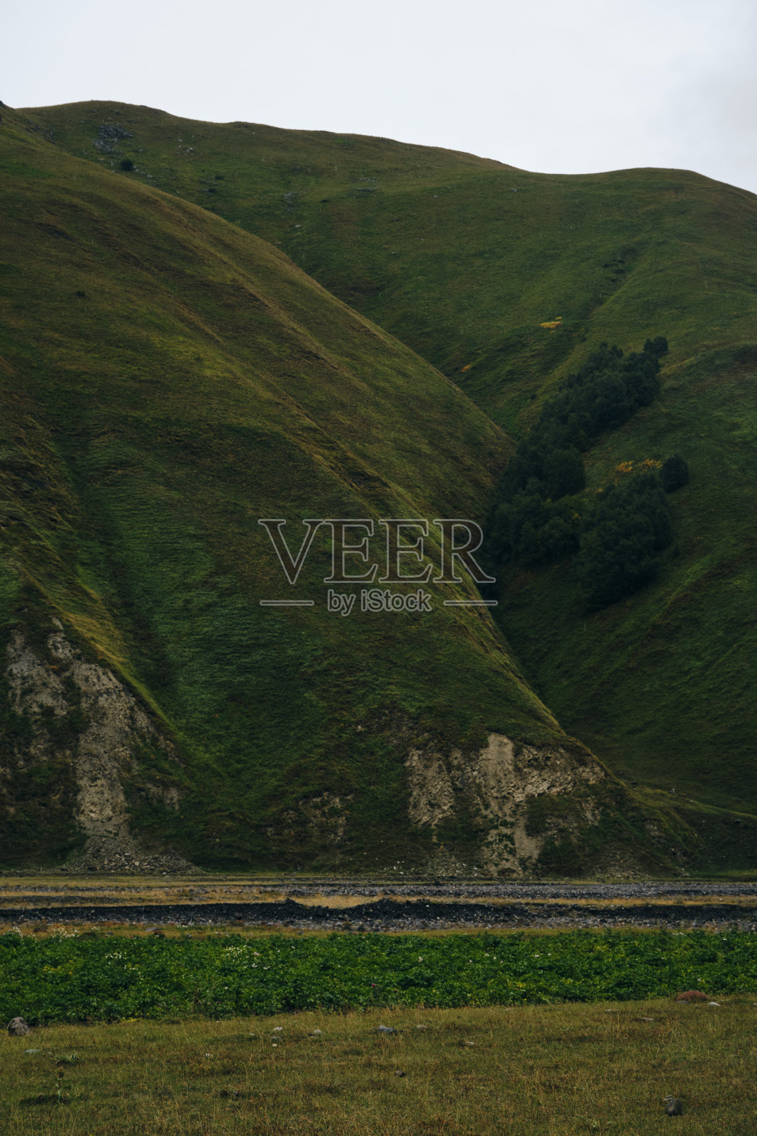 格鲁吉亚，卡兹贝格地区。从特鲁索山谷俯瞰青山和多云的天空。迷人的秋林和田野景色。照片摄影图片