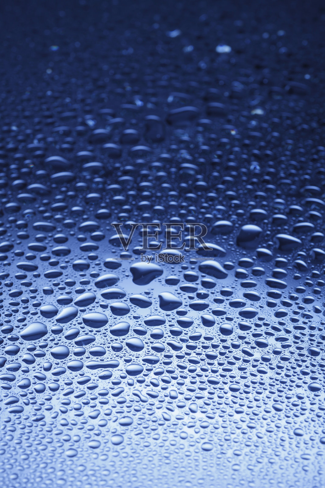 水滴在蓝色闪亮的表面上照片摄影图片
