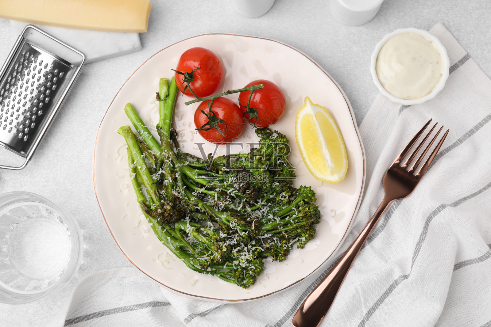 美味的西兰花，奶酪，西红柿和柠檬，在浅色的桌子上，平放照片摄影图片