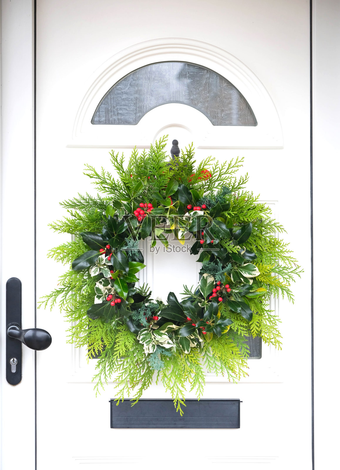 前门上挂着新鲜的冬季花环照片摄影图片