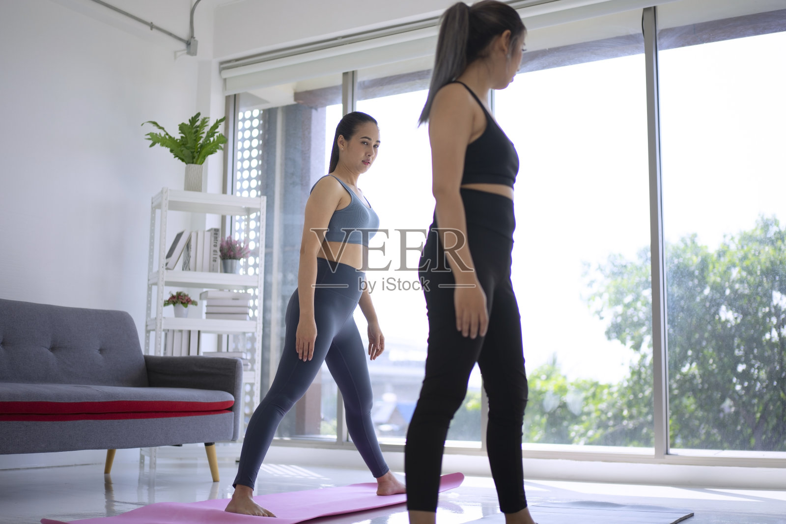 女人在家练瑜伽。照片摄影图片