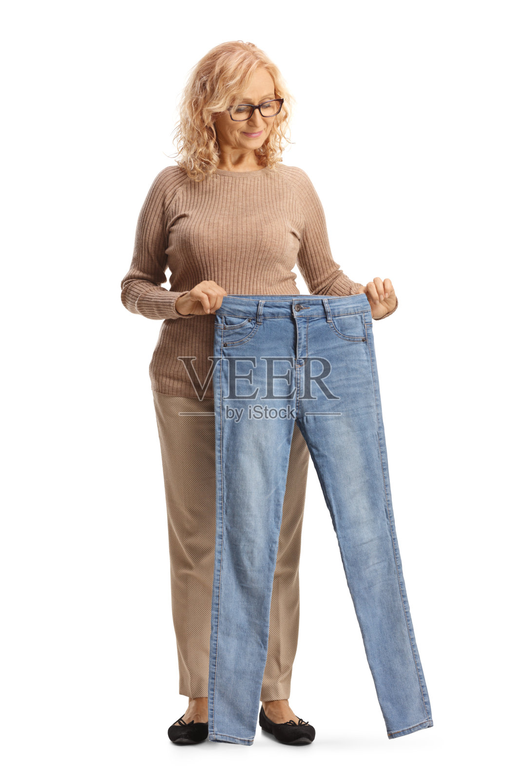 成熟的女人看着一条牛仔裤照片摄影图片